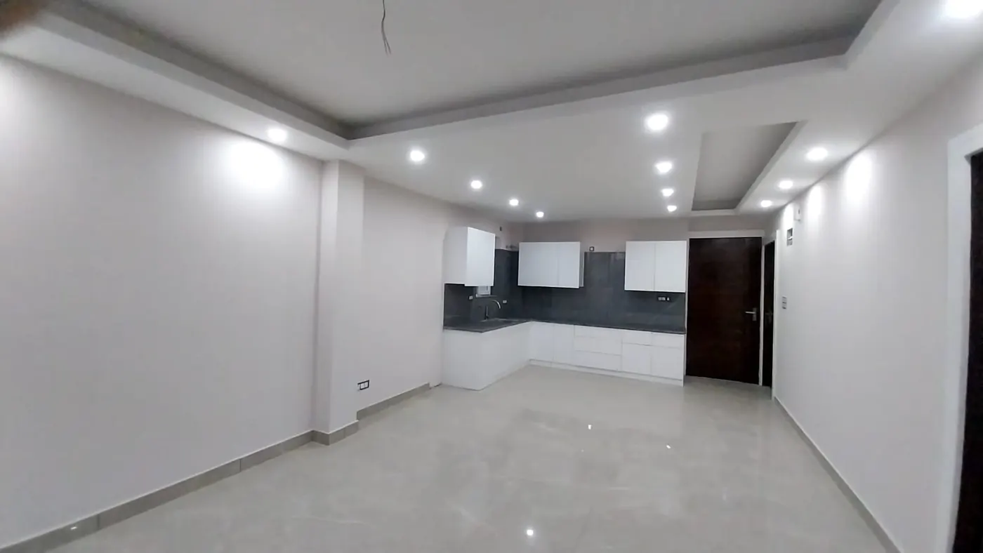 Living room with open modular kitchen and marble-finish floor