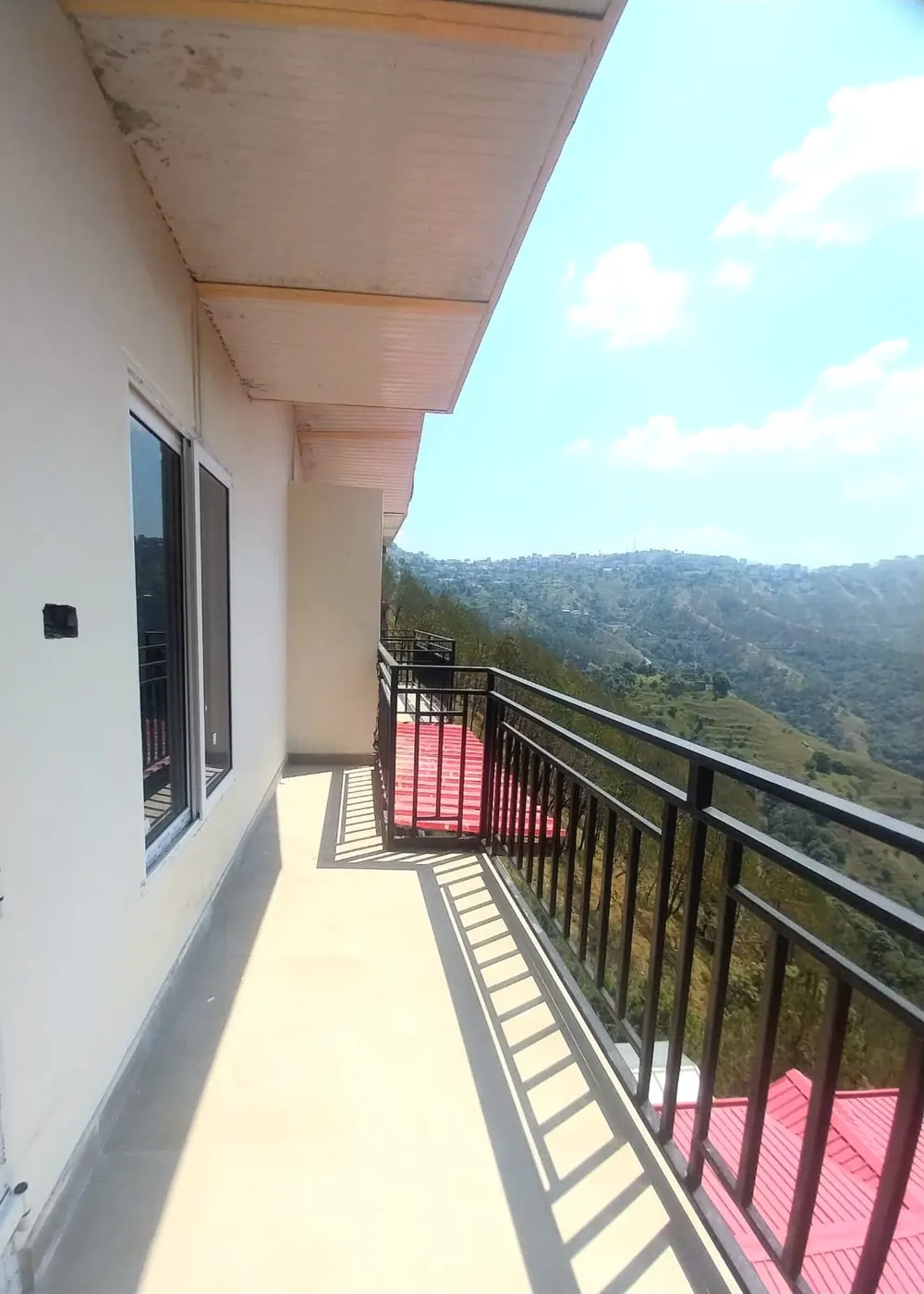 Sunlit balcony overlooking hills and Shimla town